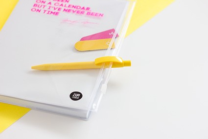 Biały notes z żółtym długopisem i kolorową zakładką